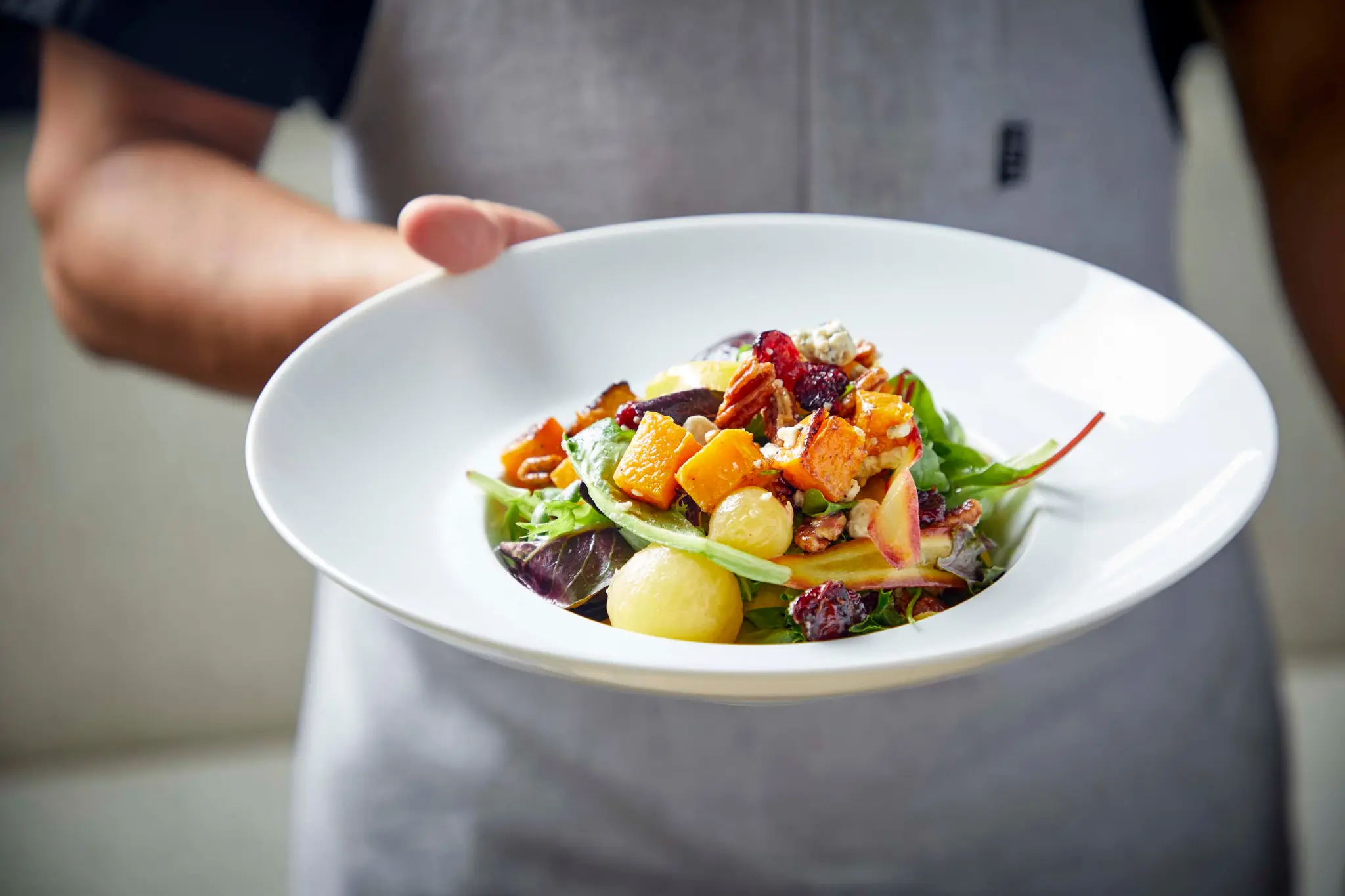 A plated seasonal salad presented by the Ambassador culinary team